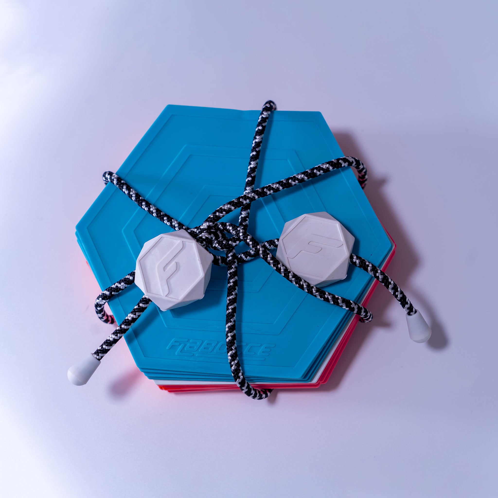 Flabocce backyard game for adults with blue hexagonal boards and white game pieces tied with black rope