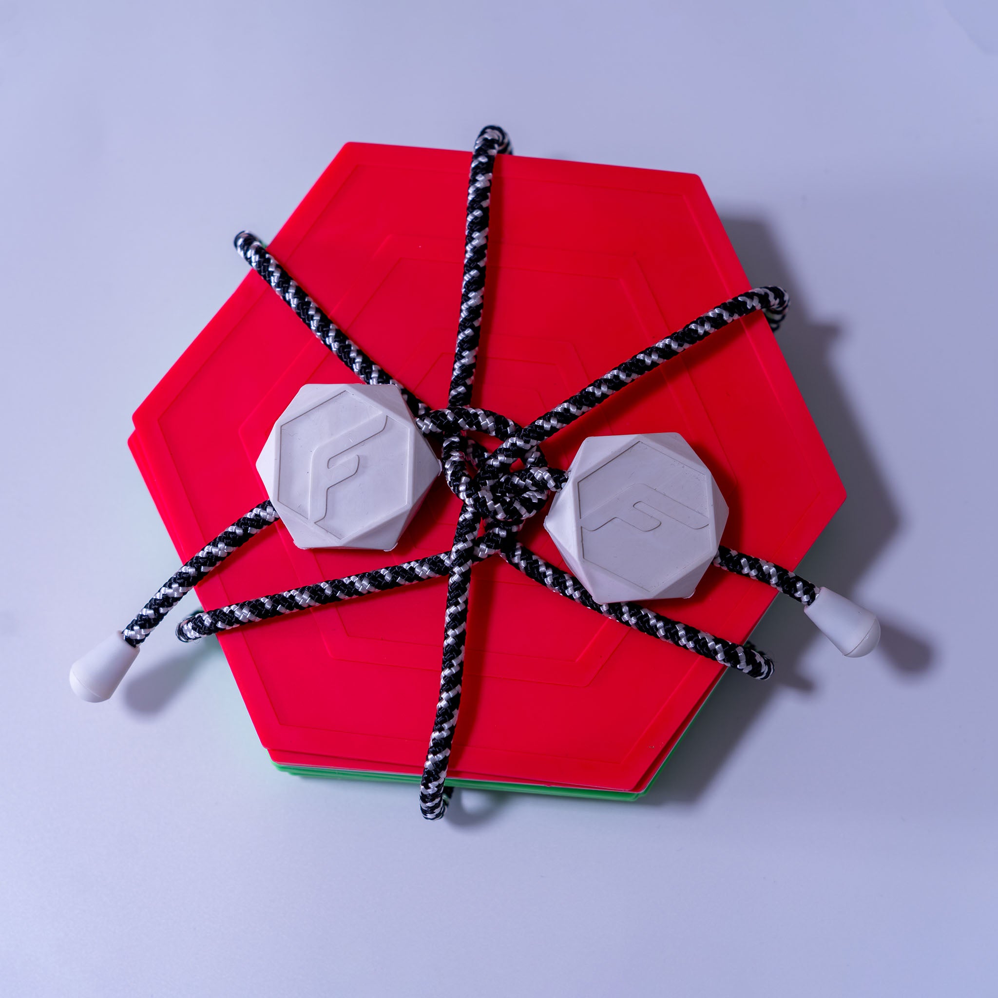 Flabocce best camping game with red and green hexagonal flabs and white target piece tied with black and white rope tool